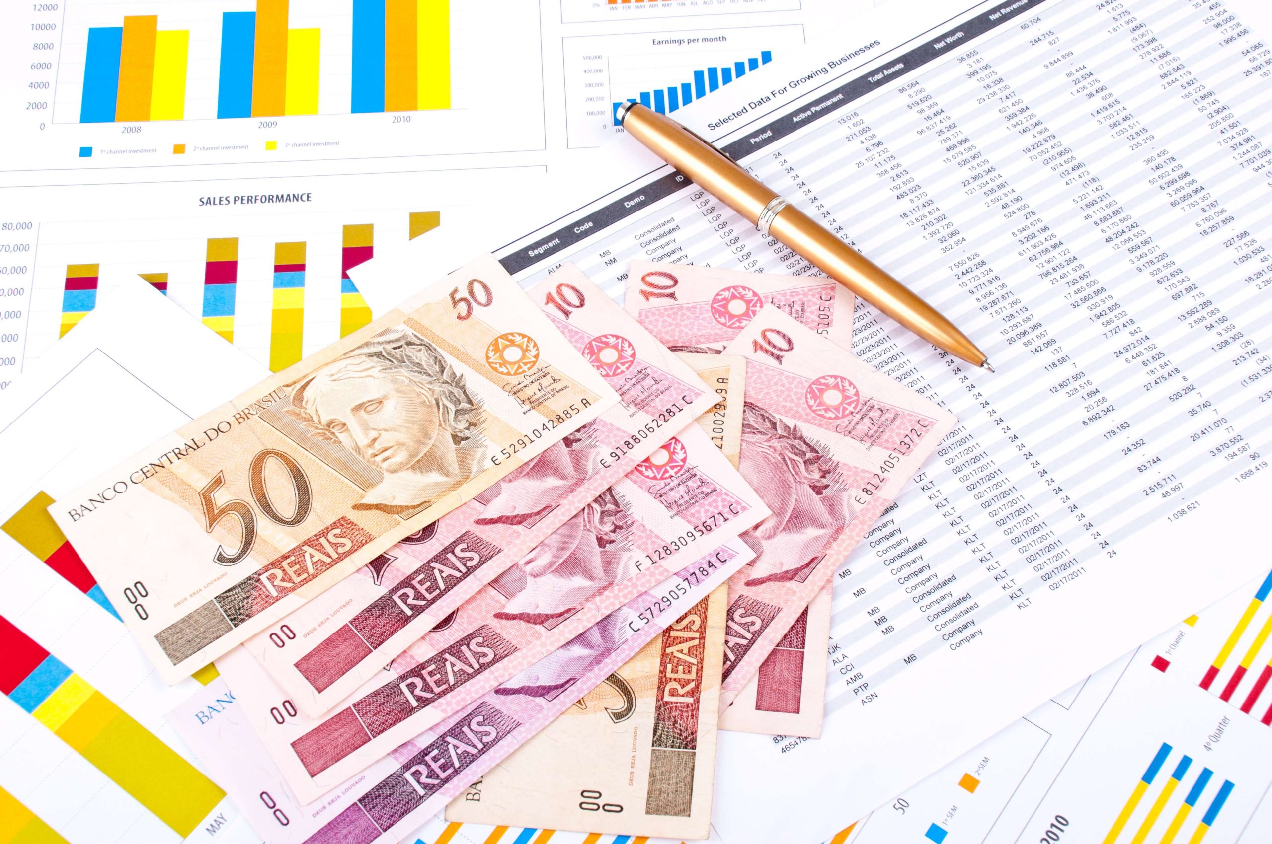 Financial chart and datasheet. Brazilian money and pen.