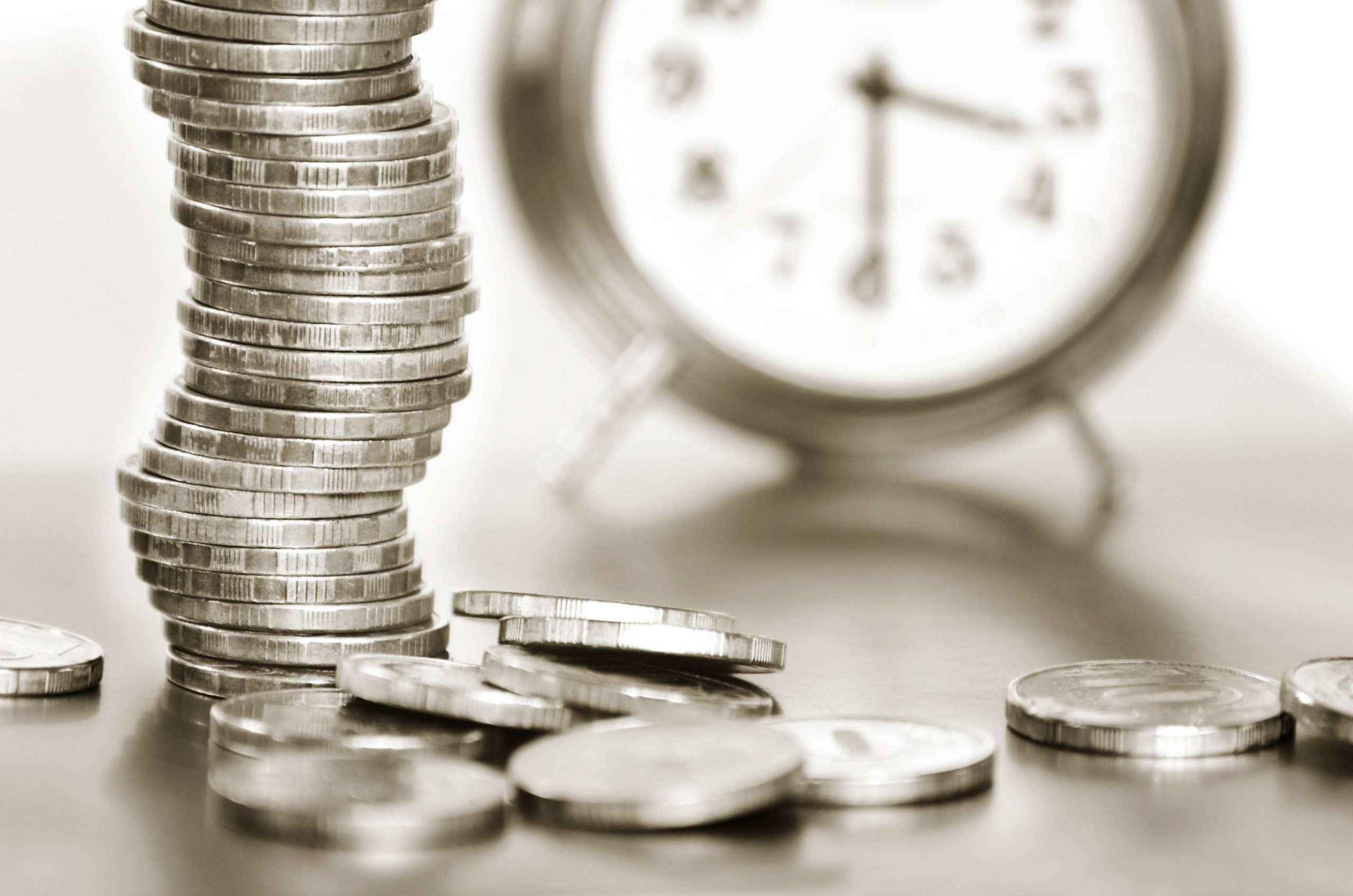 A stack of coins and alarm clock
