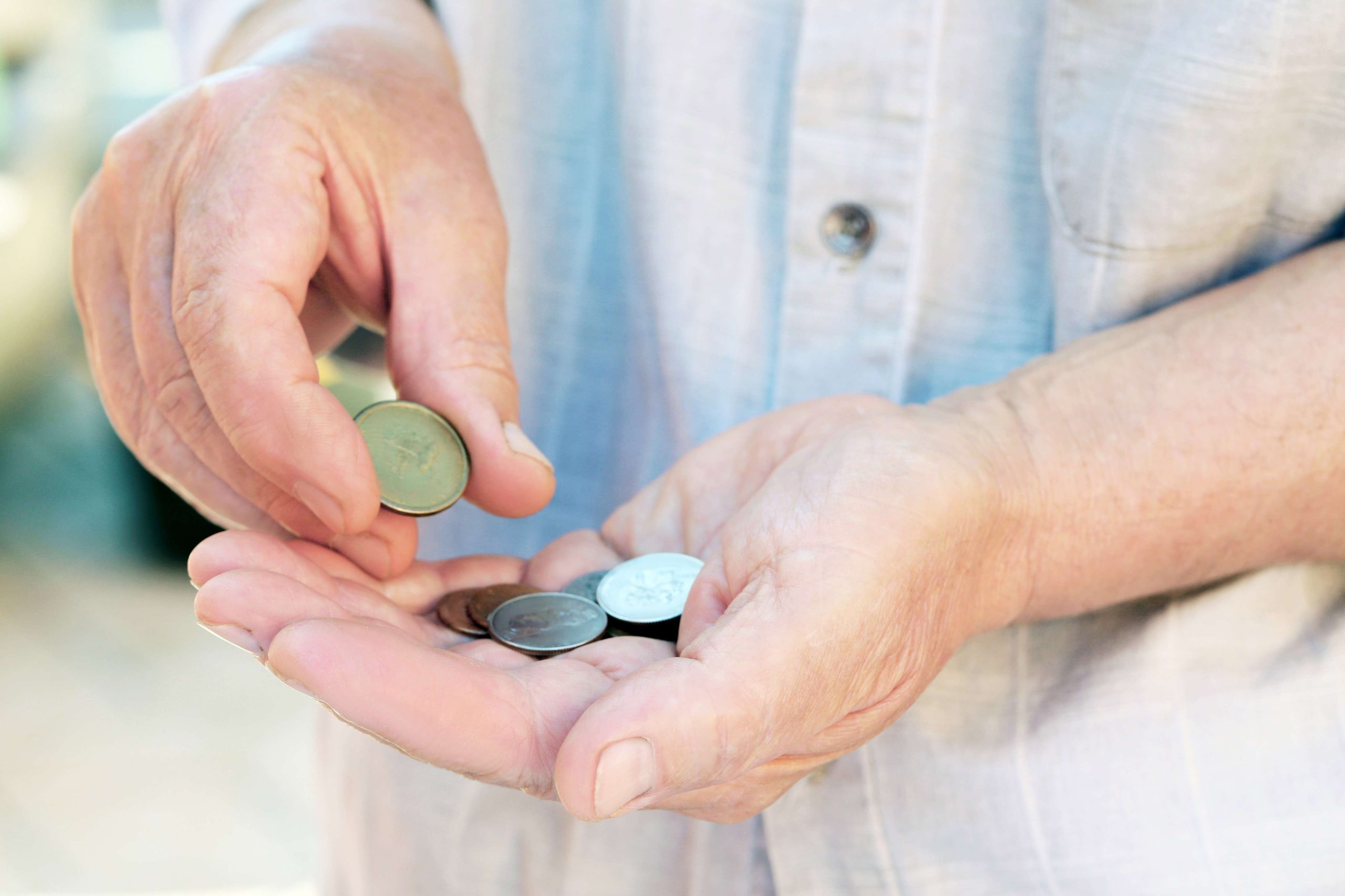 Hands of old senior with coins